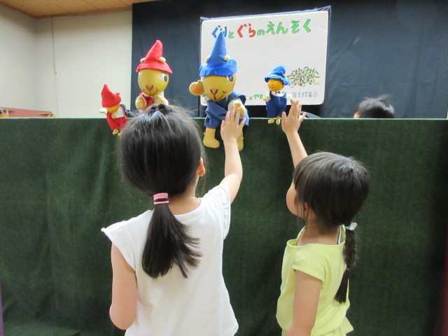 ぐりとぐらの人形と参加者がハイタッチしている写真
